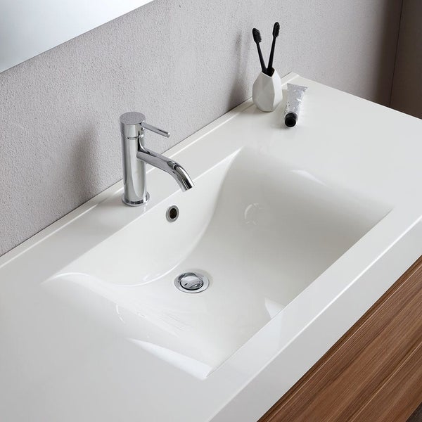 Waschbecken mit Armatur, Zahnbürsten und Zahnpasta im Badezimmer