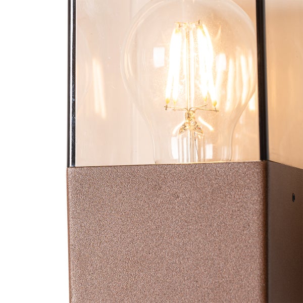 Detailansicht einer rechteckigen Außenleuchte mit LED-Filament-Leuchtmittel, klarem Glas und strukturiertem Metallgehäuse in Rostoptik.