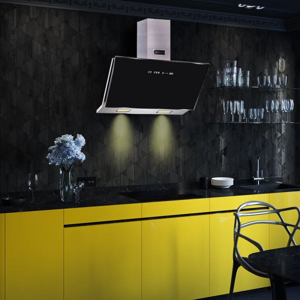 Moderne schräge Dunstabzugshaube mit Edelstahl und Glas in einer Küche mit gelben Fronten und schwarzer Arbeitsplatte