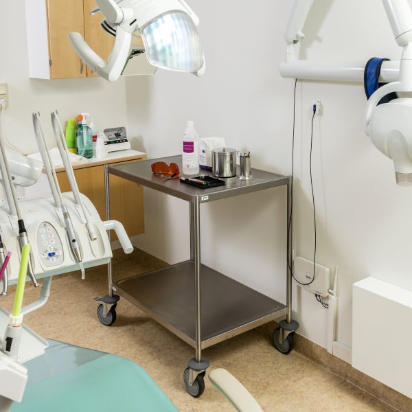 Zahnarztpraxis mit Behandlungseinheit, medizinischem Rollwagen und Geräten