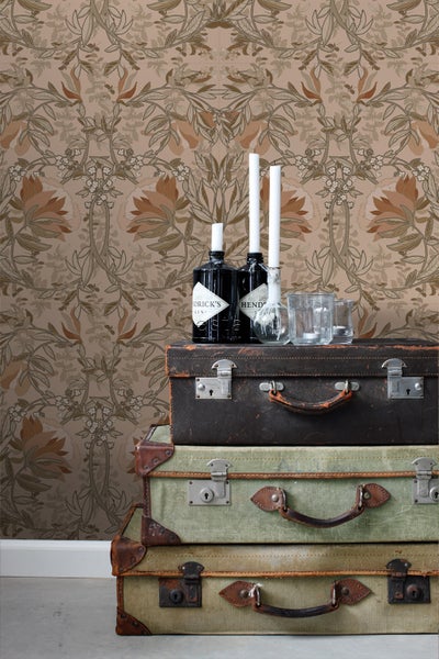 Dekorative Szene mit Stapel aus Vintage-Reisekoffern, Gin-Flaschen, Kerzen und Blumentapete