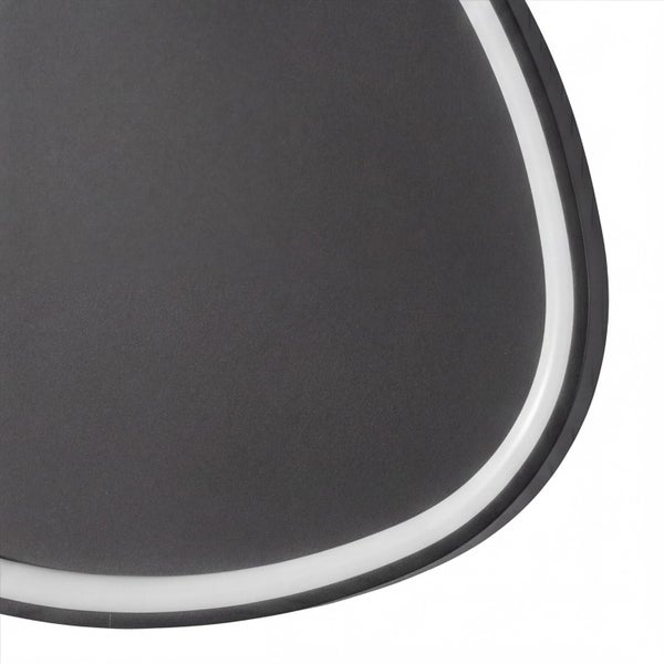 Detailaufnahme einer modernen Leuchte mit dunkelgrauer strukturierter Oberfläche und integriertem weißen Lichtstreifen.