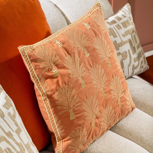 Dekokissen mit Palmenmuster auf einem Sofa