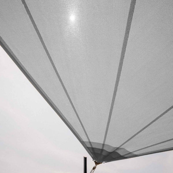Sonnensegel aus feinmaschigem, lichtdurchlässigem Gewebe mit verstärkter Ecke und Seilbefestigung an einem Mast.