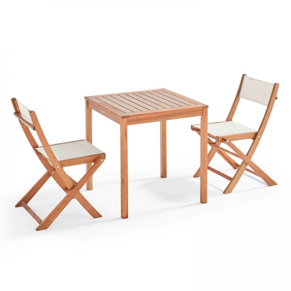 Gartenmöbel-Set aus Holz bestehend aus einem quadratischen Tisch und zwei Klappstühlen mit weißer Textilbespannung.