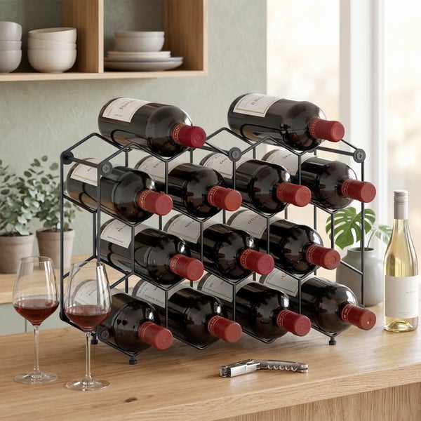 Schwarzes Weinregal aus Metall für zwölf Flaschen auf einer Holzarbeitsplatte mit Weingläsern und Korkenzieher in einer hellen Küche.