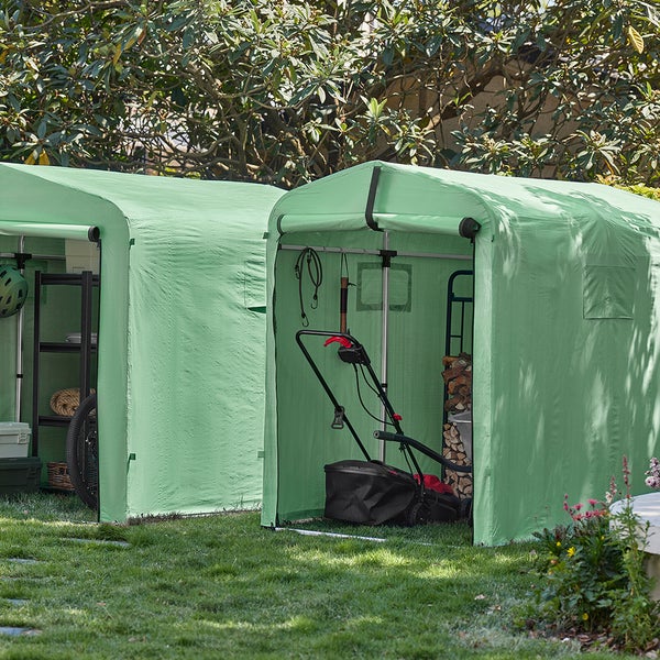Zwei grüne Gerätehäuser im Garten mit Gartengeräten