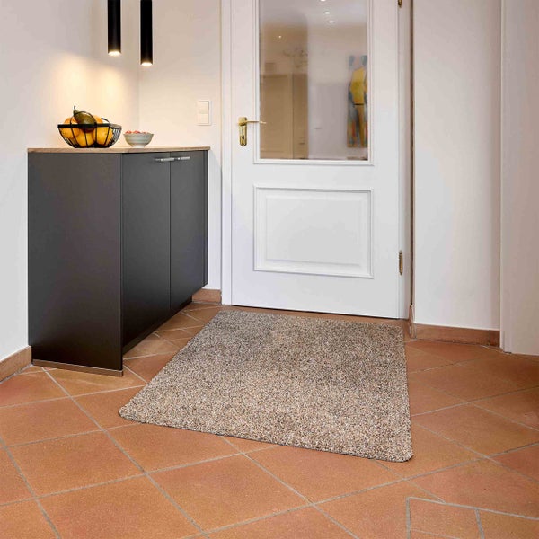 Eingangsbereich mit Fußmatte, Kommode und Tür