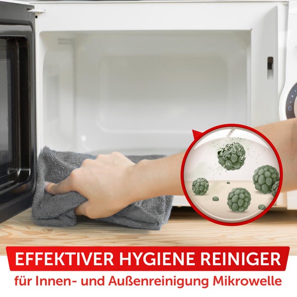 Eine Frau steht in der Nähe eines Olivenbaums in einem Topf vor einer Terrassentür, die zu einem hellen Raum führt.