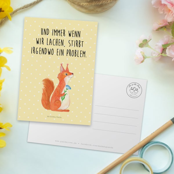 Ein Paar betrachtet lächelnd eine Grußkarte mit einem Fuchs.