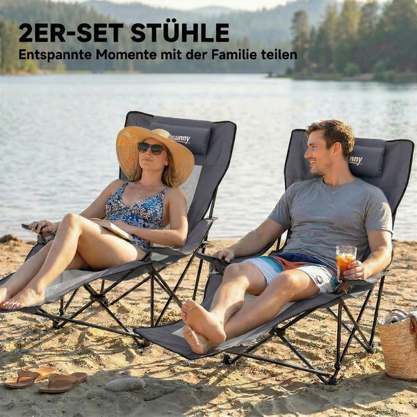 Ein Paar faltbare Campingstühle mit verstellbarer Rückenlehne für den Strand am See mit einer sitzenden Frau und einem sitzenden Mann.