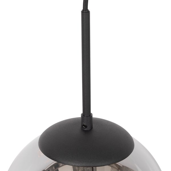 Detailansicht einer Pendelleuchte mit schwarzer Metallstange und kuppelförmiger Abdeckung auf einer Glaskugel.