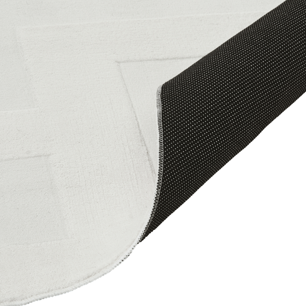 Teppich mit rutschfester Unterseite mit Noppen und geometrischem Muster auf der Oberseite.