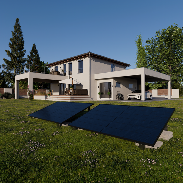 Zwei Photovoltaik-Module auf einer Rasenfläche vor einem modernen Wohnhaus mit Terrasse und Carport.