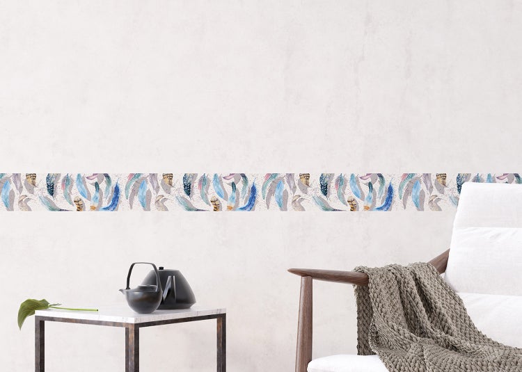 Tapetenbordüre mit Federmuster an einer hellen Wand in einem modern eingerichteten Zimmer mit Sessel und Beistelltisch.