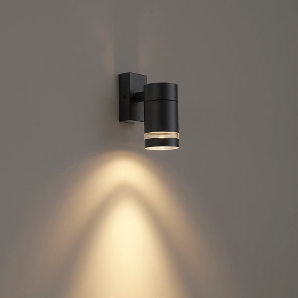 Zylindrische schwarze Außenwandleuchte mit nach unten gerichtetem Lichtkegel und transparentem Ring.