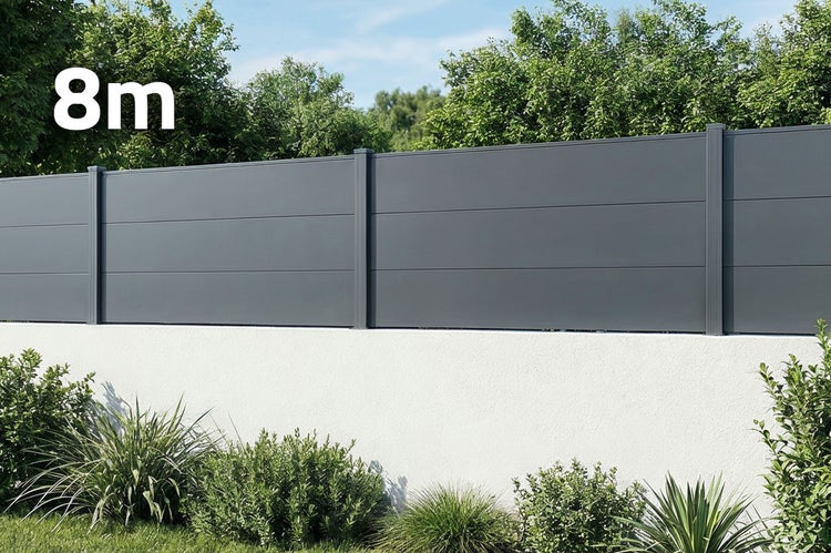 Moderner Sichtschutzzaun aus Metall mit acht Meter Gesamtlänge auf einer weißen Gartenmauer mit umliegendem Garten.