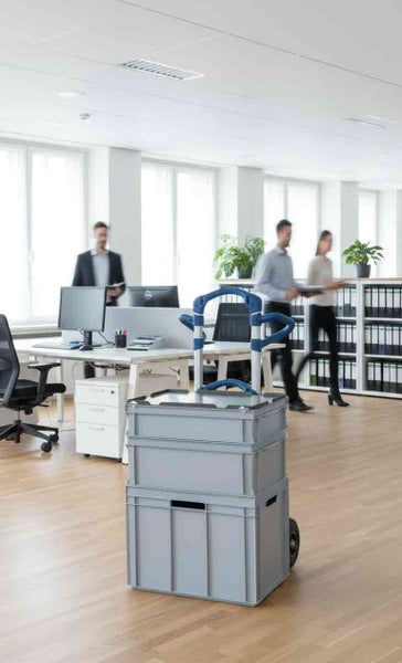 Szene eines Büros mit einem Rollwagen mit zwei Kunststoffkisten und Büroangestellten.