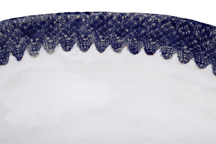 Detailansicht eines weißen Tellers mit blau gemustertem Rand