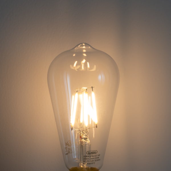 LED-Leuchtmittel ST64 in Edison-Form mit E27-Sockel, klarem Glas und leuchtenden Filamenten.