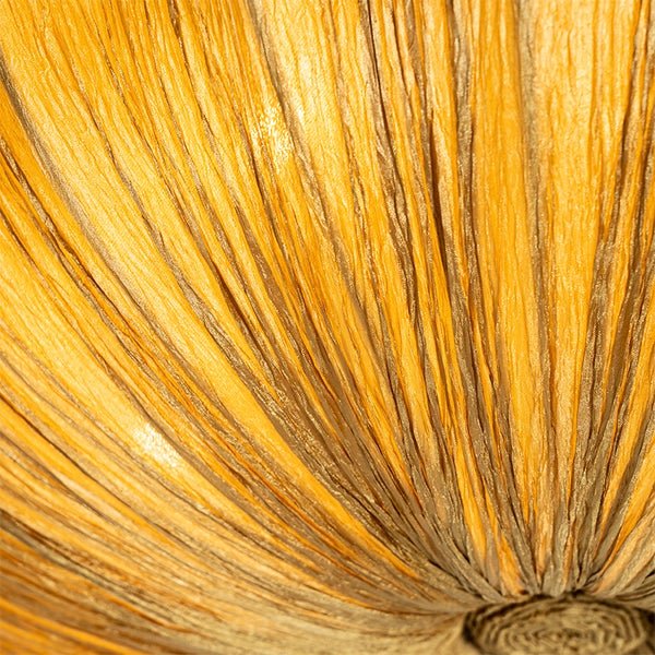 Detailaufnahme eines goldgelben, plissierten Lampenschirmstoffs mit feiner Textur.