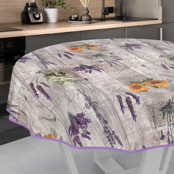 Runde Tischdecke mit rustikalem Holzdekor, Lavendel-, Sonnenblumen- und Olivenmotiven sowie violettem Rand in einer modernen Küche.