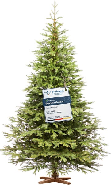 Künstlicher Fairytrees Weihnachtsbaum FT06 mit Prüfsiegel für geprüfte Qualität auf einem Holzständer stehend.