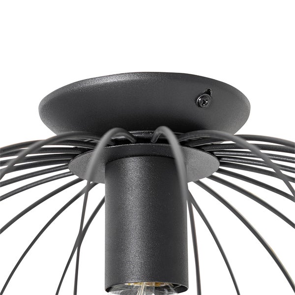 Detailaufnahme einer schwarzen Deckenleuchte mit Drahtgestell