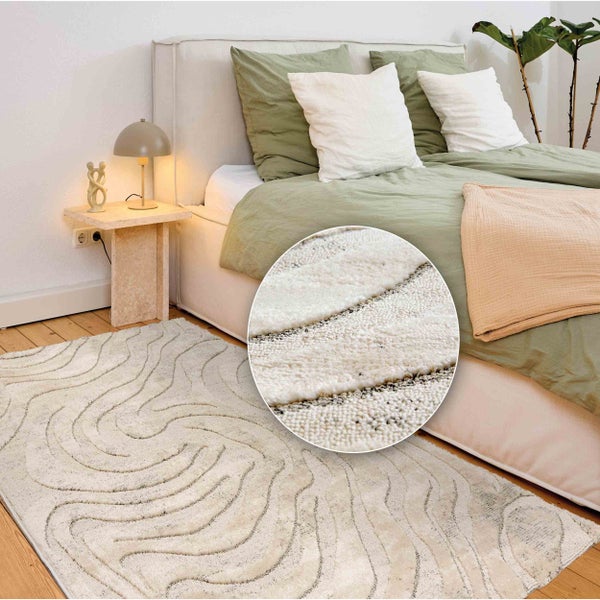 Schlafzimmer mit Bett, Nachttisch und beigem Teppich mit Muster