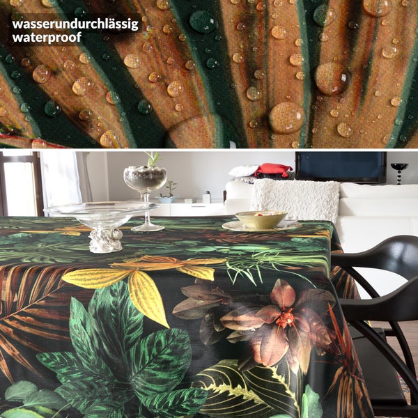 Wasserundurchlässige Tischdecke mit tropischem Blättermuster in einem hellen Wohnzimmer, Detailansicht von Wassertropfen auf dem Stoff.