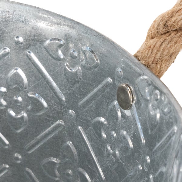 Nahaufnahme eines verzinkten Metalleimers mit geprägtem Ornamentmuster und einem Griff aus dickem Hanfseil.