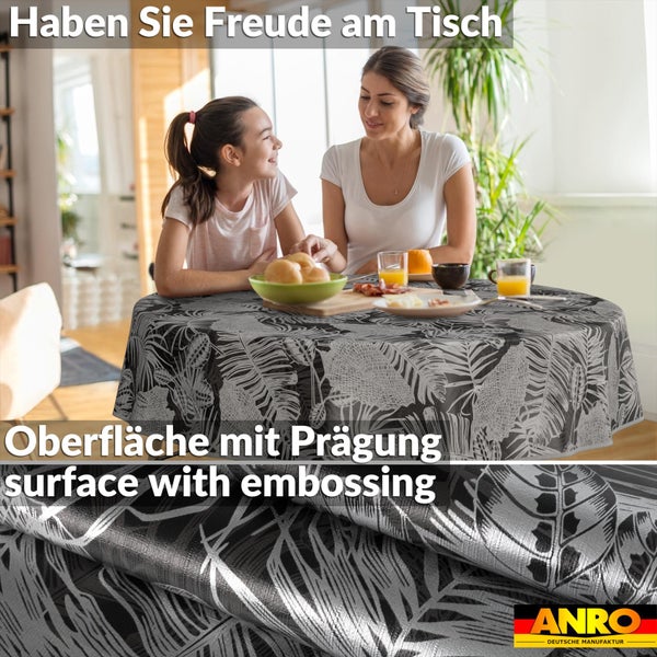 Runde Tischdecke mit tropischem Blattmuster und geprägter Oberfläche in einem hellen Esszimmer mit Mutter und Tochter. ANRO Logo.