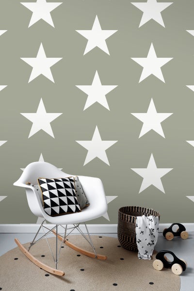 Kinderzimmer mit Sternentapete, Schaukelstuhl und Teppich