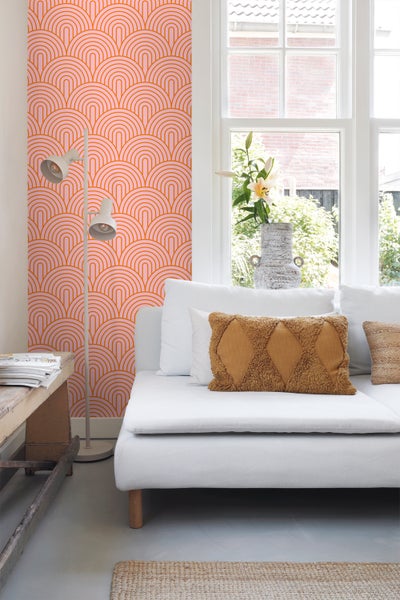Helles Wohnzimmer mit Couch, Stehlampe und Tapete mit grafischem Muster