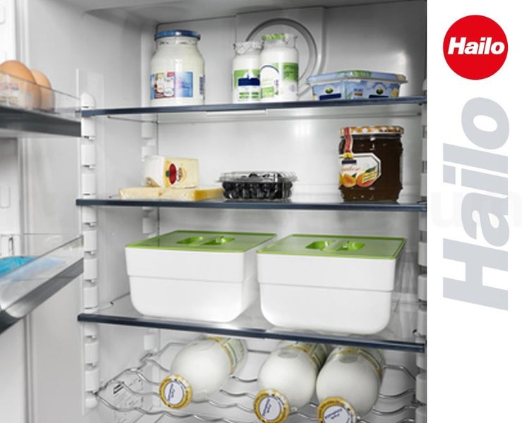 Organisierter Kühlschrank mit Hailo Aufbewahrungsboxen auf Glasregalen und verschiedenen Lebensmitteln. Hailo Logo.