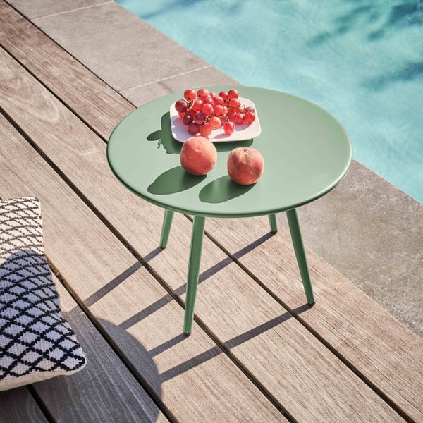 Runder grüner Metall-Beistelltisch auf einer Holzterrasse am Pool mit Obstschale, helles und organisiertes Ambiente.