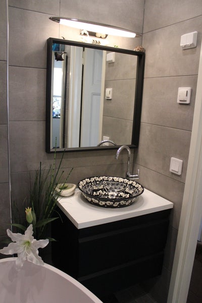 Modernes Badezimmer mit Waschbecken, Spiegel und Beleuchtung