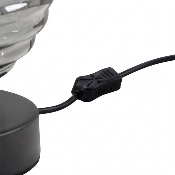 Detailansicht eines schwarzen Stromkabels mit integriertem Schnurschalter für eine Lampe.