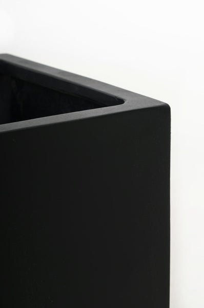 Nahaufnahme der Ecke eines schwarzen Pflanzgefäßes mit matter Oberfläche.