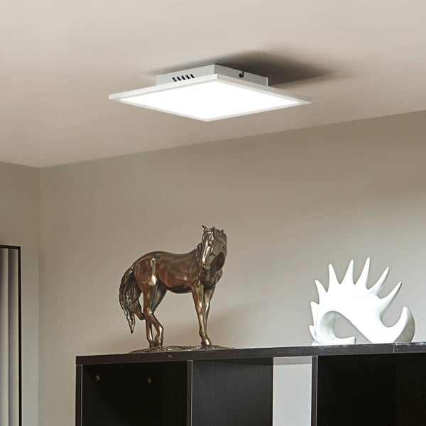 Quadratische LED-Deckenleuchte in einem modern eingerichteten Raum über einem Regal mit einer Pferdefigur und einer Skulptur.