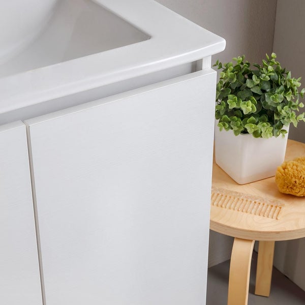 Detailansicht eines weißen Waschtischunterschranks neben einem Hocker mit Dekoration