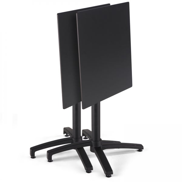 Zwei schwarze Bistrotische mit klappbarer quadratischer Tischplatte und platzsparendem Gestell.