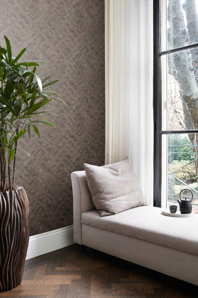 Wohnzimmer mit brauner Ziegel-Tapete im Fischgrätmuster, Tagesbett und Zimmerpflanze