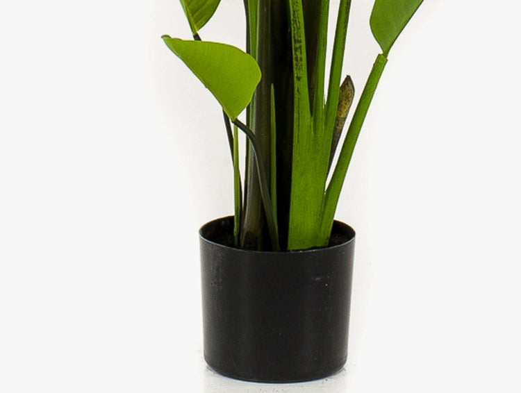 Künstliche Palme im schwarzen Topf mit strukturiertem Stamm und grünen Wedeln.