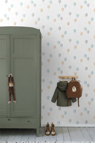 Kinderzimmer mit Tapete mit Ballonmuster, einem grünen Kleiderschrank und einer Garderobe mit Bärenrucksack.