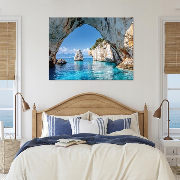 Schlafzimmer mit Bett und einem Wandbild, das eine Felsformation im Meer zeigt
