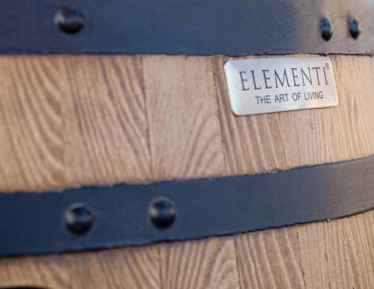 Elementi Logo auf einer Oberfläche mit Holzoptik, Metallbändern und Nieten.