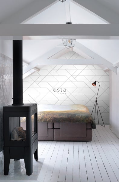 Schlafzimmer mit Kaminofen, Bett, Stehlampe und Esta Home Tapete mit geometrischem Muster