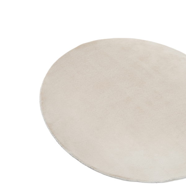 Runder, weicher Teppich mit flauschiger Oberfläche in Beige.
