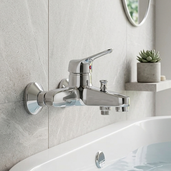 Verchromte Einhebel-Wannenarmatur zur Wandmontage in einem hellen Badezimmer mit Natursteinoptik-Fliesen über einer weißen Badewanne.
